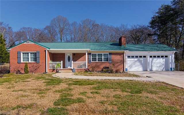 single story home featuring a porch, a chimney, a front lawn, concrete driveway, and an attached garage