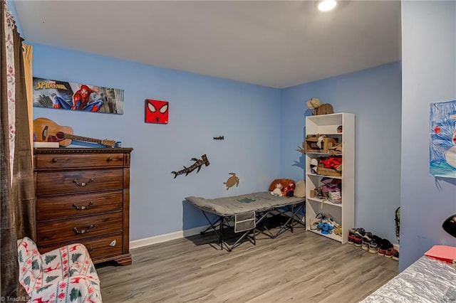bedroom with baseboards and wood finished floors