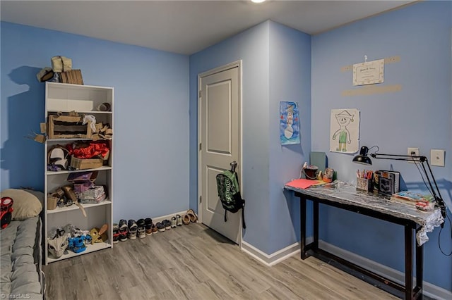 interior space with baseboards and wood finished floors