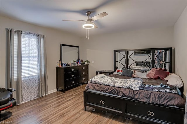 bedroom with baseboards, ceiling fan, and wood finished floors