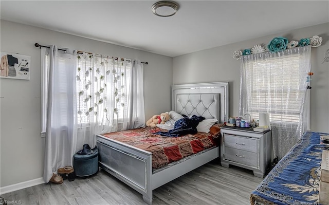 bedroom with baseboards and wood finished floors
