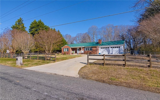 ranch-style home featuring fence, a front yard, a chimney, concrete driveway, and an attached garage