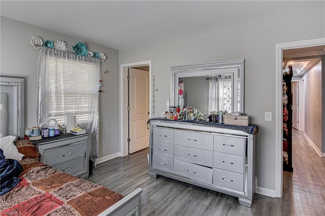 bedroom with baseboards and wood finished floors