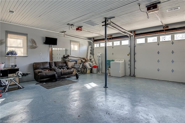 garage featuring a garage door opener, washer / clothes dryer, and visible vents