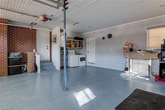 garage with visible vents, washer and clothes dryer, and a garage door opener