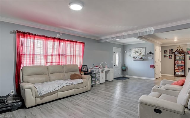 living area with baseboards, ornamental molding, and wood finished floors