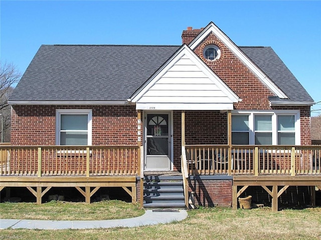 view of front of property featuring covered porch, brick siding, roof with shingles, and a chimney