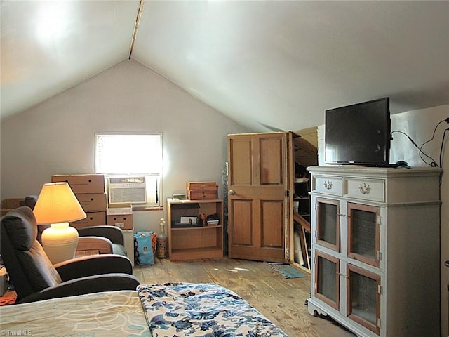 living area featuring cooling unit, light wood-style flooring, and vaulted ceiling