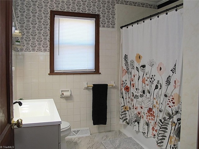 full bath with wallpapered walls, tile walls, and vanity