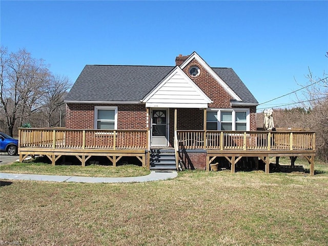 view of front of home with a front lawn, a chimney, brick siding, and a shingled roof