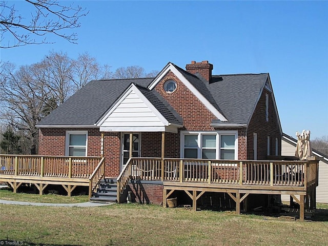 view of front of home featuring brick siding, a shingled roof, and a front lawn