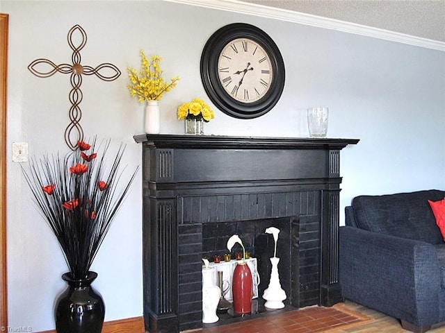 interior details with a fireplace, wood finished floors, a textured ceiling, and ornamental molding