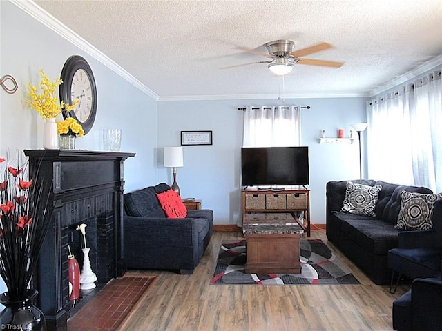 living area with ceiling fan, a textured ceiling, wood finished floors, and crown molding