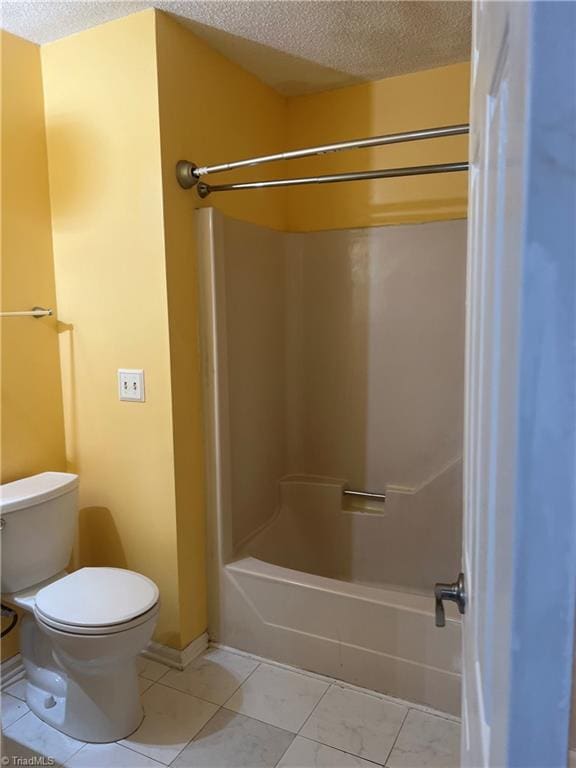 bathroom with bathtub / shower combination, tile patterned flooring, a textured ceiling, and toilet