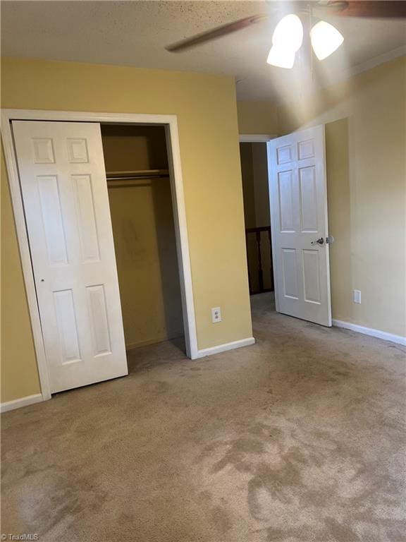 unfurnished bedroom with light carpet, ceiling fan, and a closet