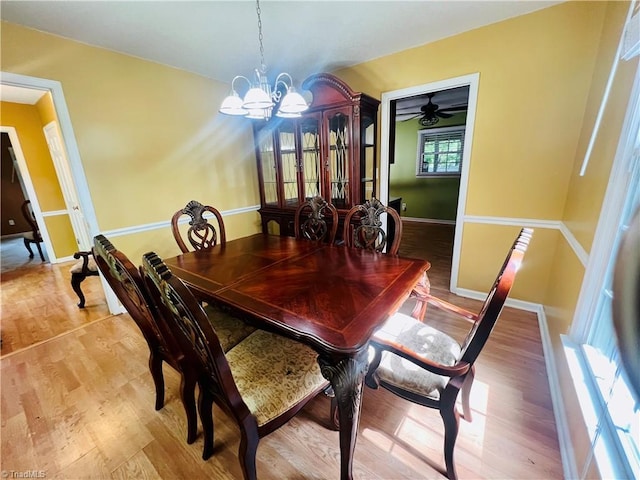 dining space featuring ceiling fan with notable chandelier, light hardwood / wood-style flooring, and plenty of natural light