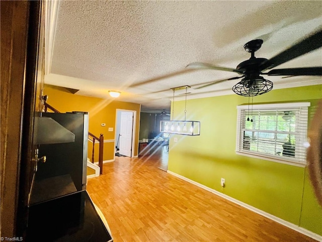 interior space featuring a textured ceiling, hardwood / wood-style floors, and ceiling fan