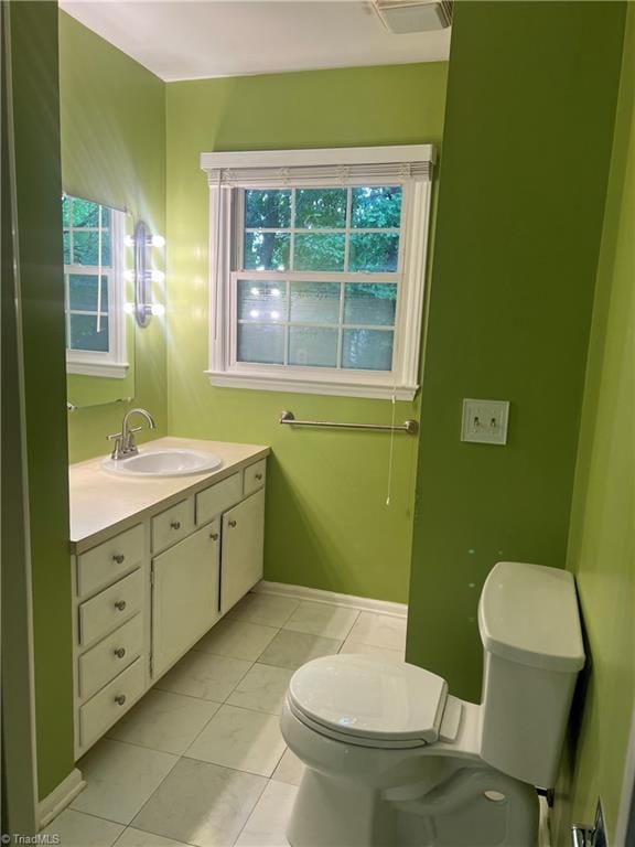 bathroom featuring vanity, tile patterned flooring, and toilet