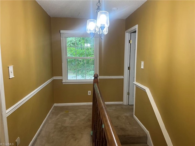 stairs featuring a textured ceiling and carpet flooring