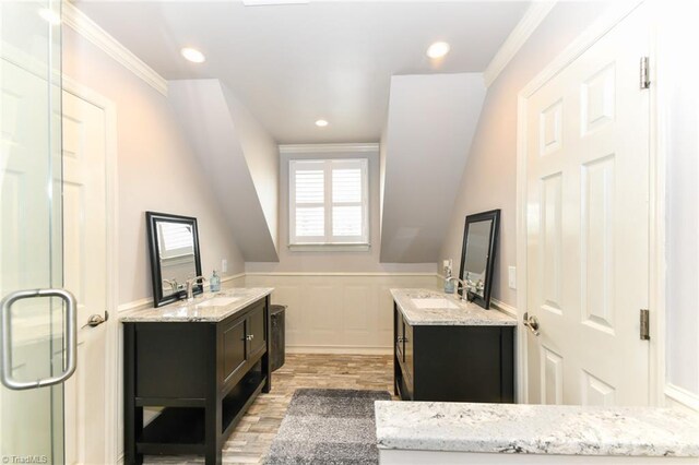 bathroom featuring wood-type flooring, ornamental molding, walk in shower, and vanity