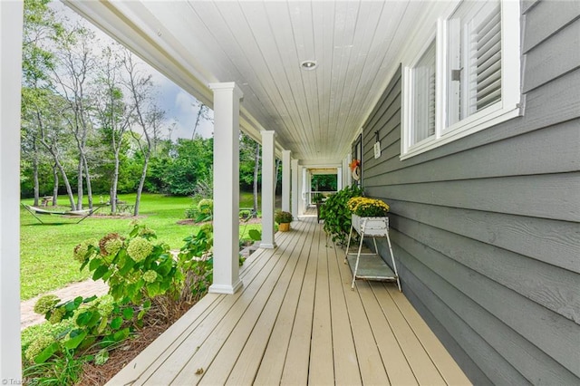 deck featuring a porch and a yard