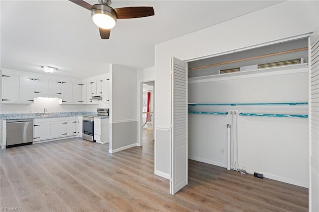 kitchen with stainless steel appliances, ceiling fan, white cabinets, and light wood-type flooring