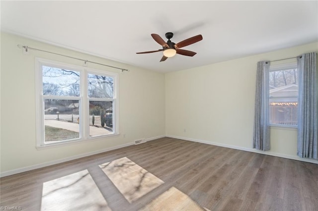 spare room with hardwood / wood-style flooring, plenty of natural light, and ceiling fan