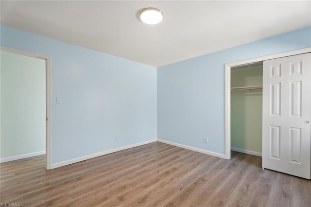 unfurnished bedroom with a closet and light wood-type flooring