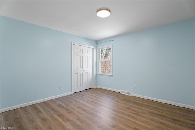 unfurnished bedroom with hardwood / wood-style floors and a closet