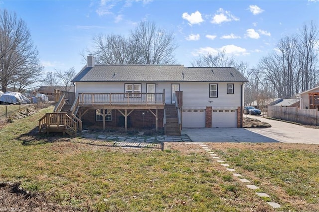 back of property with a garage, a lawn, and a deck