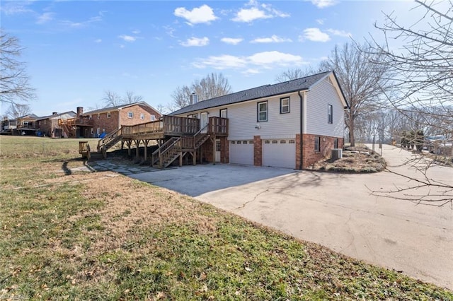 view of front of home featuring a garage, a wooden deck, a front yard, and central AC unit