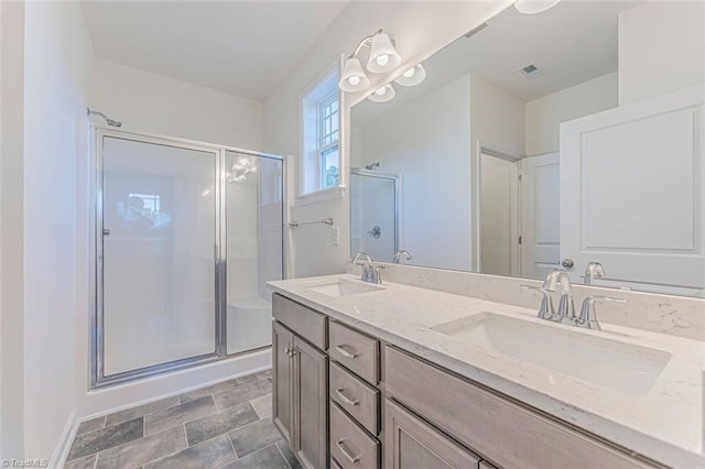 bathroom featuring an enclosed shower, tile floors, dual sinks, and vanity with extensive cabinet space