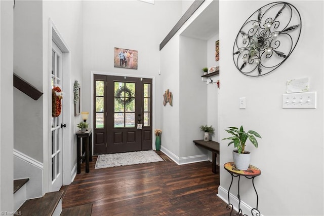 entrance foyer with a towering ceiling and dark hardwood / wood-style flooring