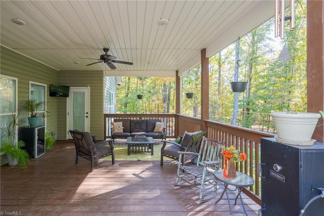 wooden terrace with an outdoor hangout area and ceiling fan