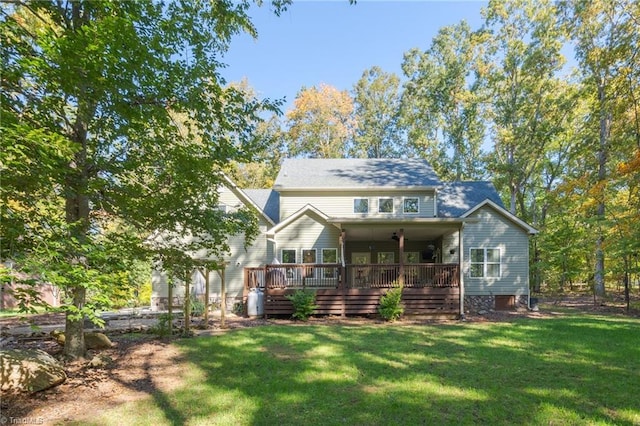 rear view of house with a deck and a lawn