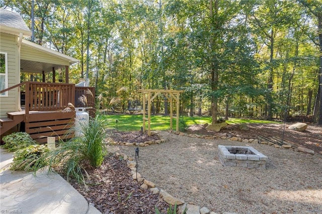 view of yard featuring a wooden deck and a fire pit