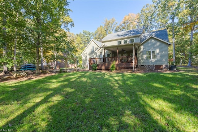 back of property with a wooden deck, ceiling fan, a yard, and central AC unit