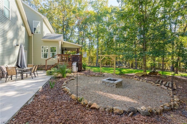 view of yard featuring a deck, a patio area, and an outdoor fire pit