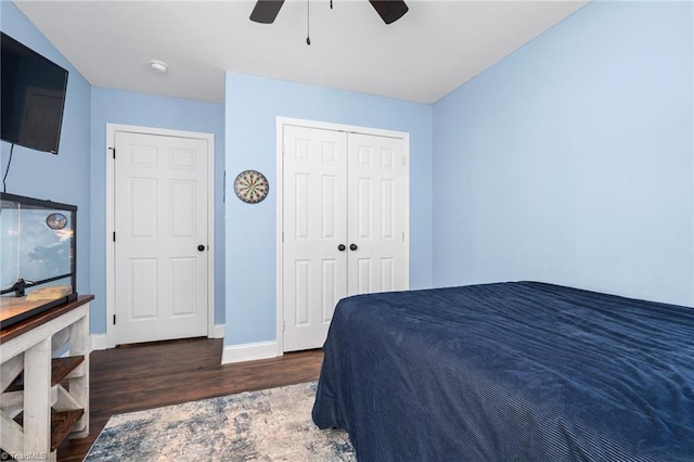 bedroom with dark wood-type flooring, ceiling fan, and a closet