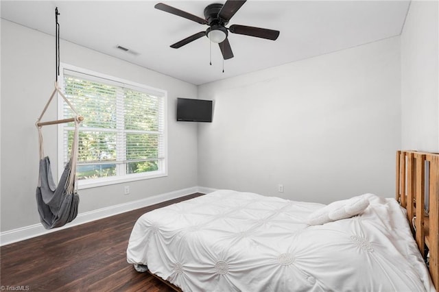 bedroom with dark hardwood / wood-style floors and ceiling fan