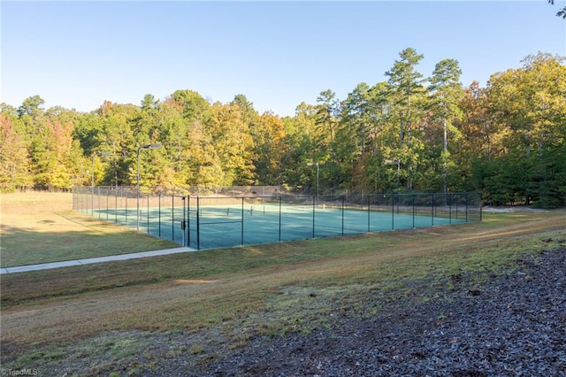 view of tennis court featuring a yard