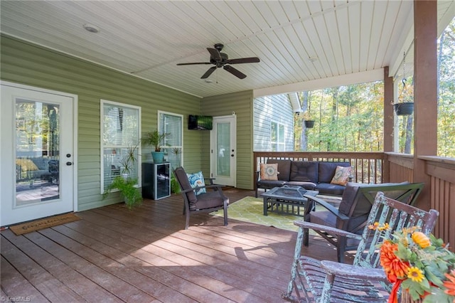 wooden terrace with an outdoor hangout area and ceiling fan