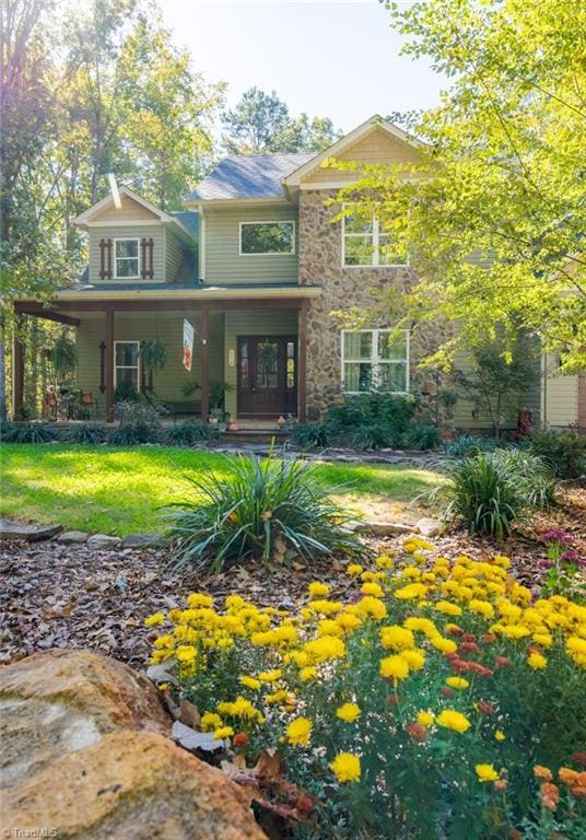 view of front of house featuring covered porch and a front lawn