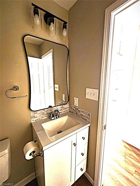 bathroom featuring hardwood / wood-style flooring, vanity, and toilet