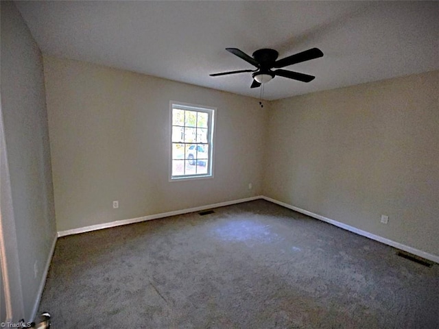 empty room featuring ceiling fan and dark colored carpet