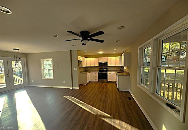 kitchen with white cabinets, appliances with stainless steel finishes, a wealth of natural light, and pendant lighting