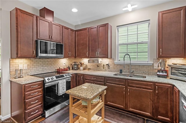 1934 Rubywood St, Greensboro, NC 27405 - kitchen featuring a sink, appliances with stainless steel finishes, tasteful backsplash, and light stone counters