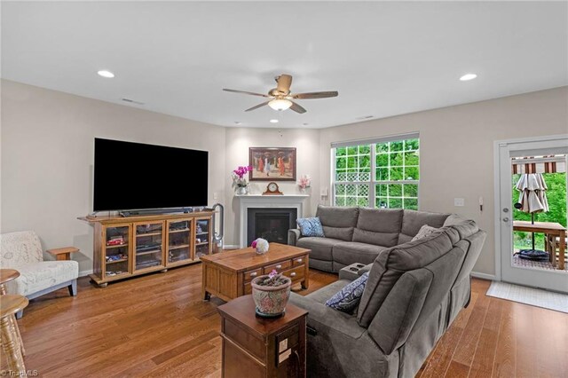 1934 Rubywood St, Greensboro, NC 27405 - living room featuring a ceiling fan, recessed lighting, a glass covered fireplace, and light wood-style flooring