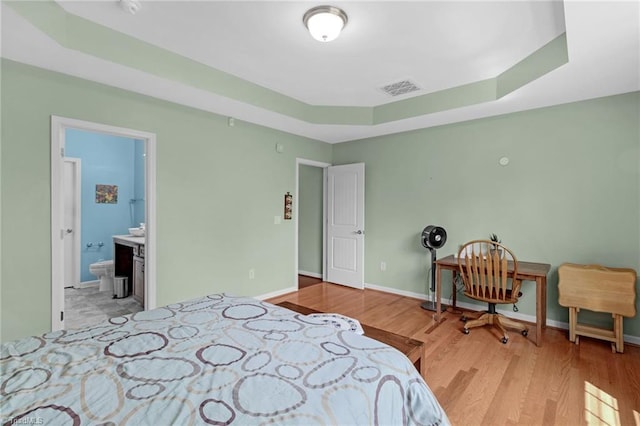 1934 Rubywood St, Greensboro, NC 27405 - bedroom featuring baseboards, visible vents, wood finished floors, and a raised ceiling