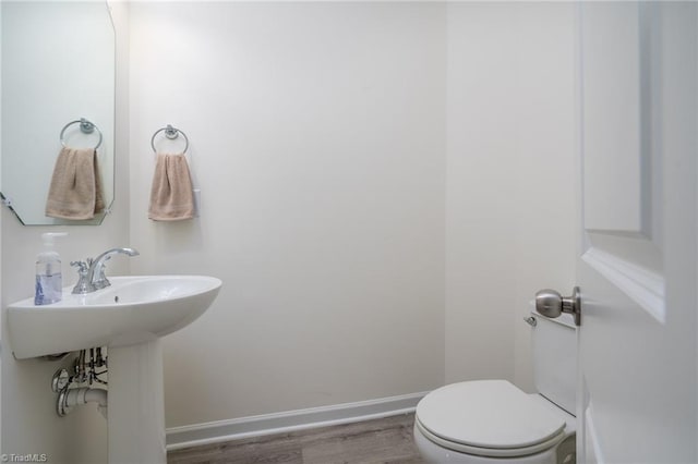 bathroom with toilet and wood-type flooring